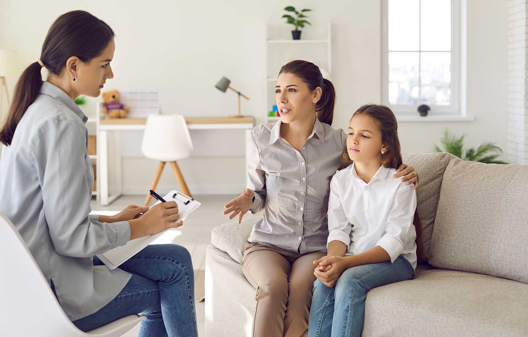 A parent and child talking with a psychologist