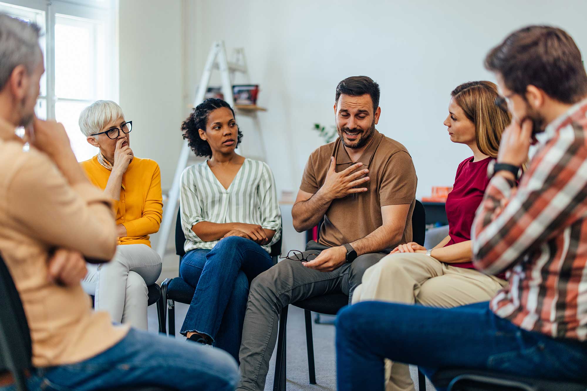 Group of parents sitting in a circle talking.