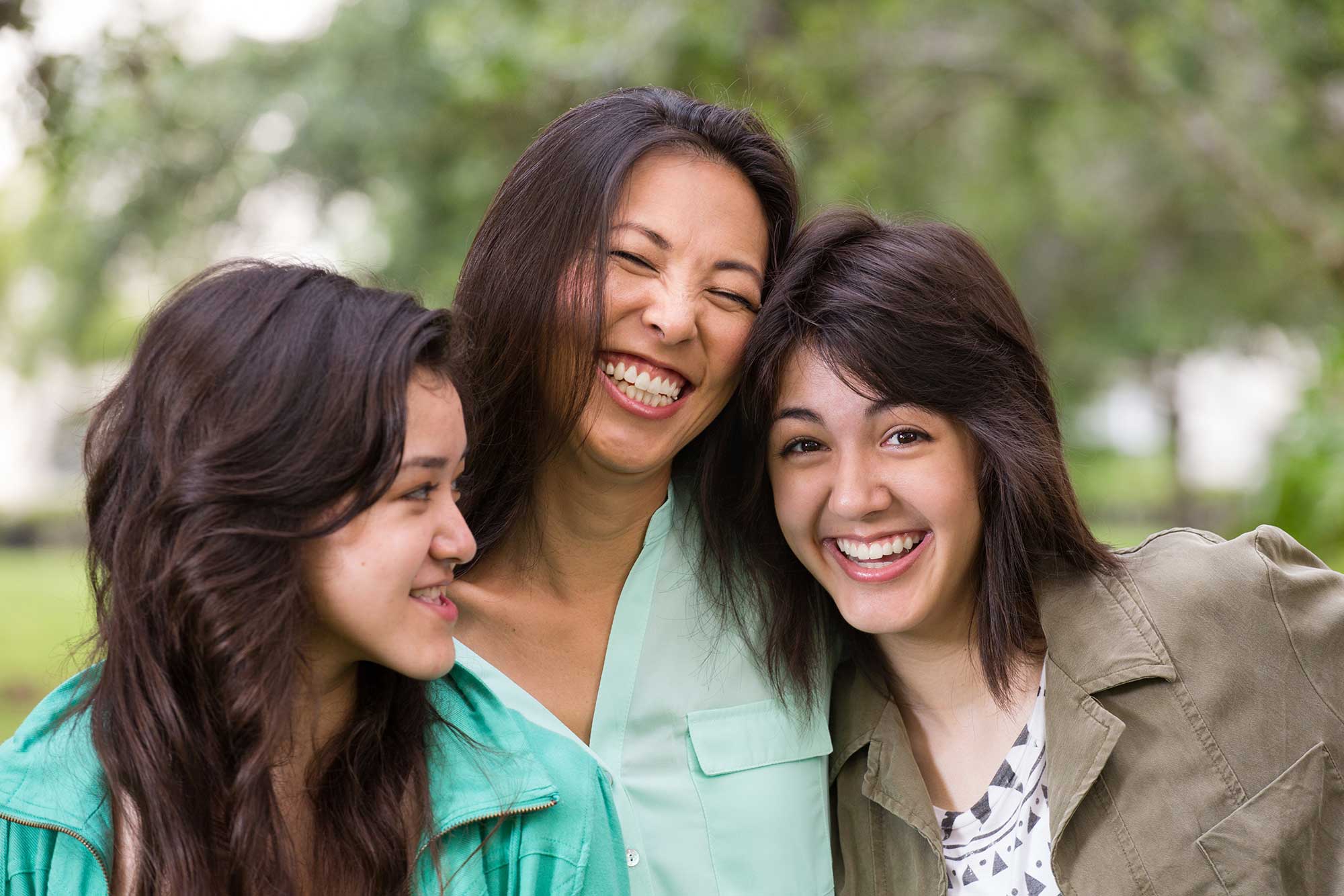 Parent and two siblings smiling