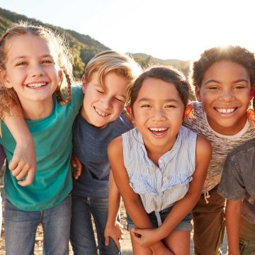 Group of children huddled together smiling.