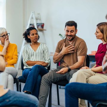 Group of parents sitting in a circle talking.