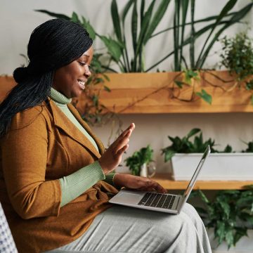 Adult sitting with a laptop participating in a tele-health session